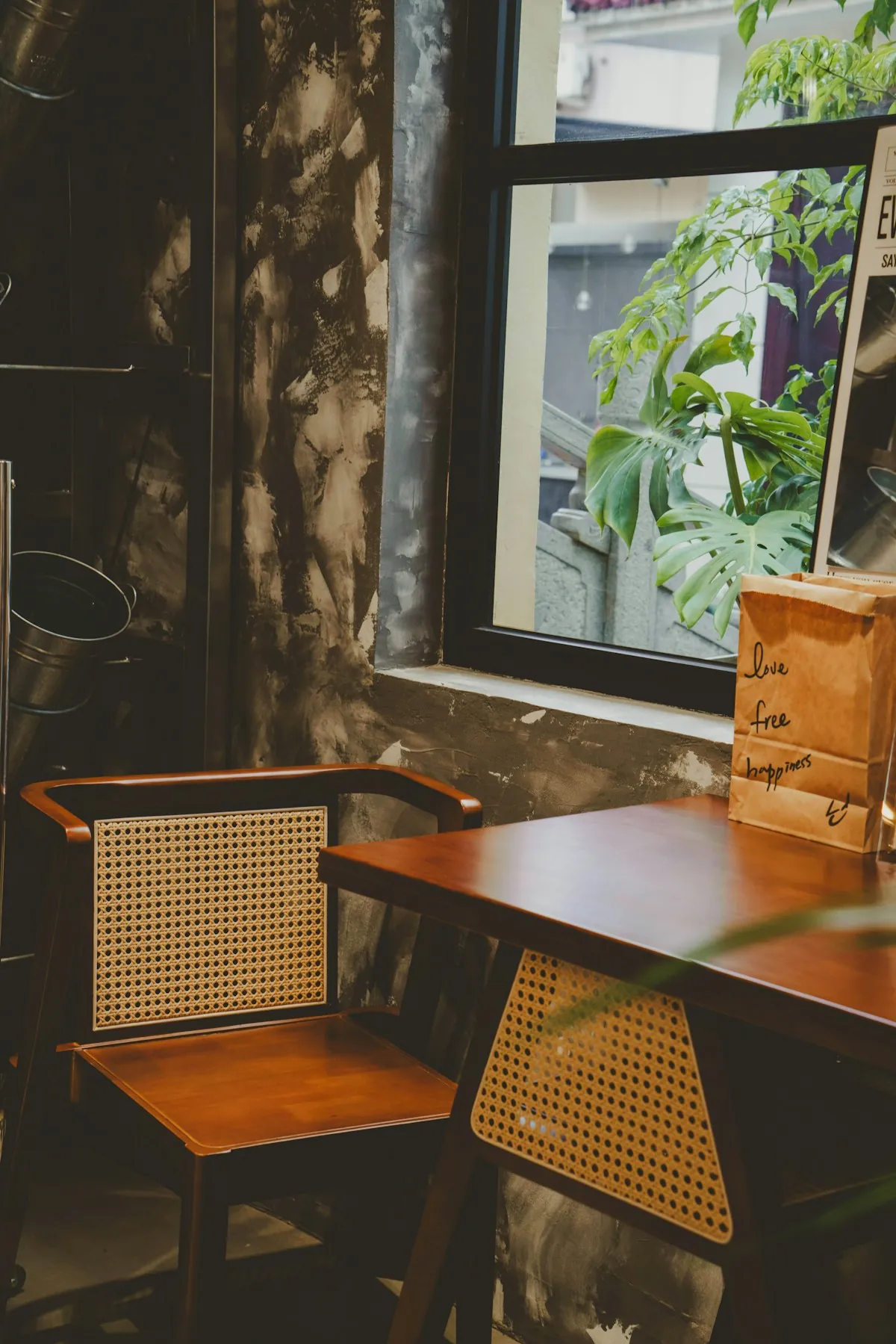 Wooden desk and rattan chair by a window